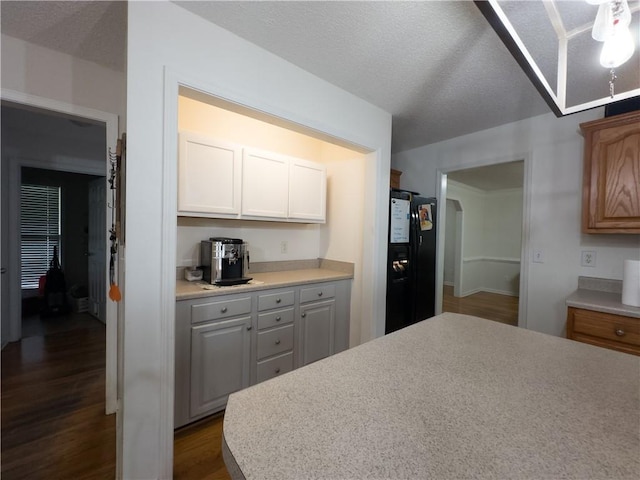 111 Bexley Ln, Douglasville, GA 30134 - kitchen featuring black fridge with ice dispenser, dark wood-style floors, and light countertops