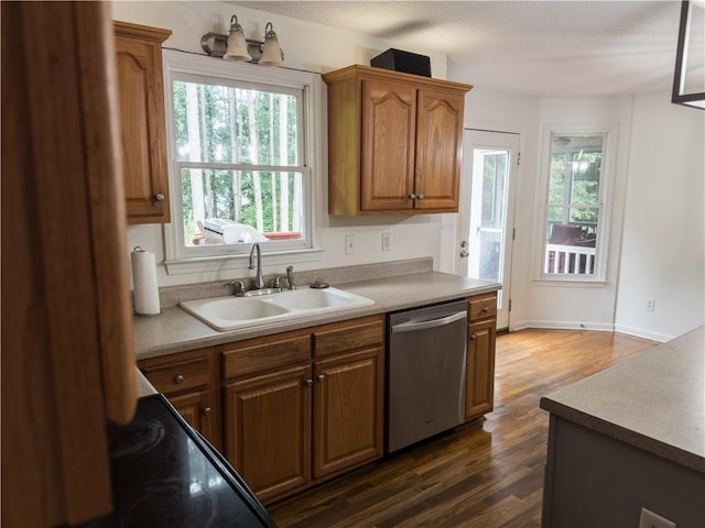 111 Bexley Ln, Douglasville, GA 30134 - kitchen featuring stainless steel dishwasher, a sink, brown cabinetry, dark wood finished floors, and light countertops