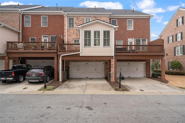 back of house featuring brick siding, driveway, an attached garage, and central AC unit