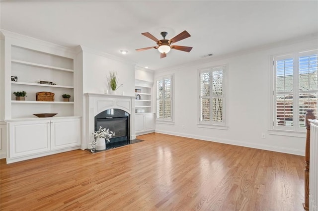 unfurnished living room featuring ornamental molding, light wood-type flooring, a fireplace with flush hearth, and baseboards