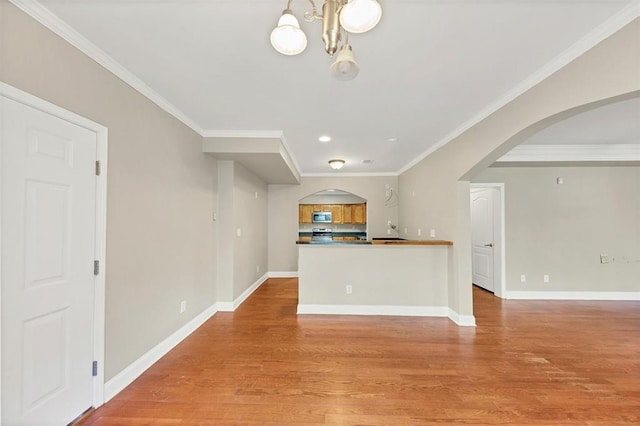 kitchen with an inviting chandelier, ornamental molding, and light wood-type flooring