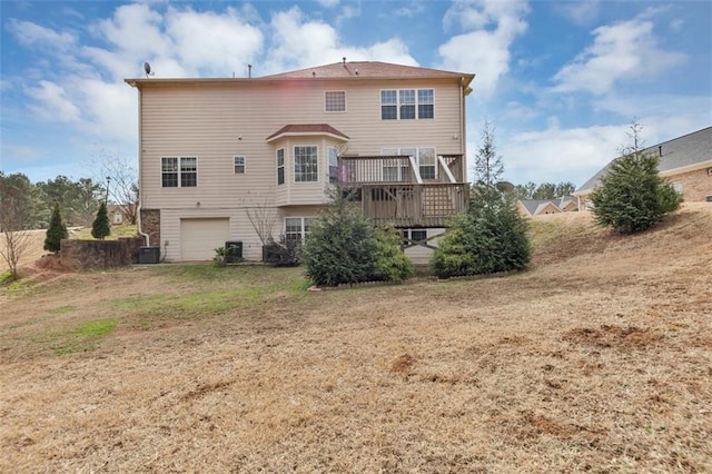 rear view of house with a yard, a garage, and a deck