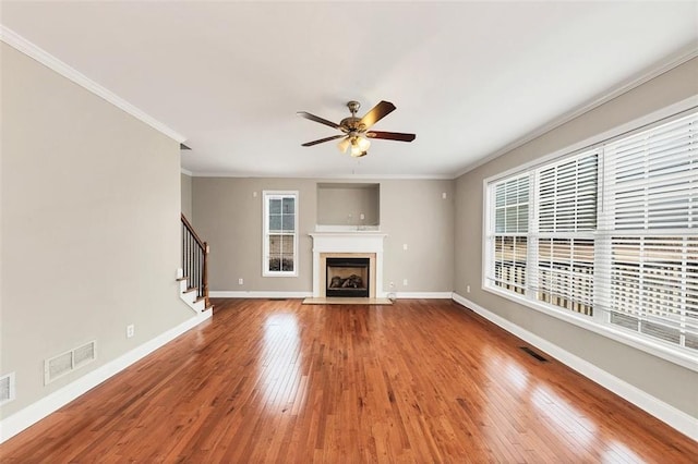 unfurnished living room with ornamental molding, ceiling fan, and light wood-type flooring