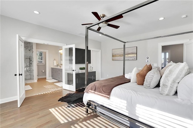 bedroom with ceiling fan, ensuite bathroom, and light hardwood / wood-style floors