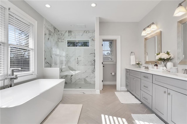 bathroom with dual vanity, plenty of natural light, parquet flooring, and independent shower and bath