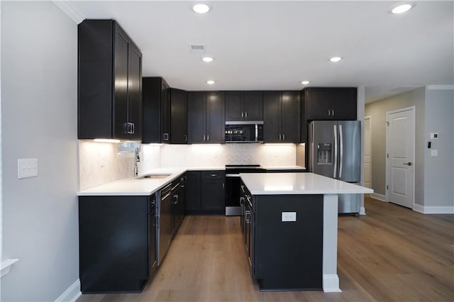 kitchen with stainless steel appliances, a center island, sink, and backsplash