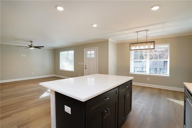 kitchen with pendant lighting, crown molding, and a kitchen island