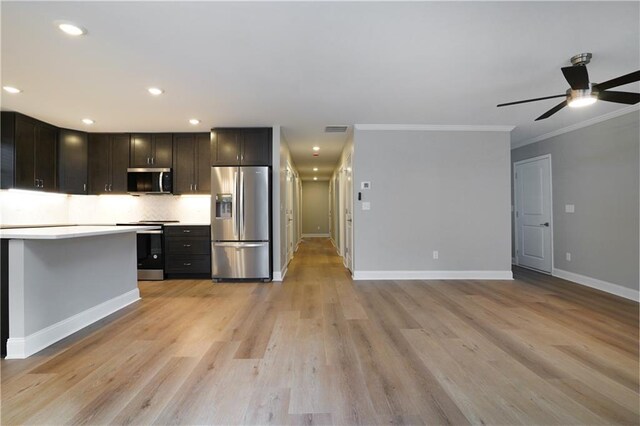 kitchen featuring appliances with stainless steel finishes, backsplash, ornamental molding, ceiling fan, and light hardwood / wood-style flooring