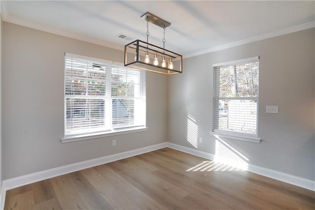 unfurnished dining area with crown molding and hardwood / wood-style flooring