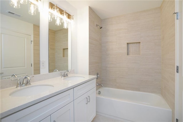 bathroom featuring vanity and tiled shower / bath