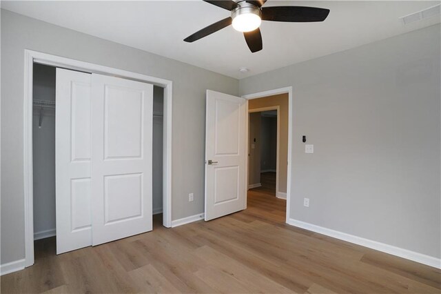 unfurnished bedroom featuring a closet, ceiling fan, and light hardwood / wood-style flooring