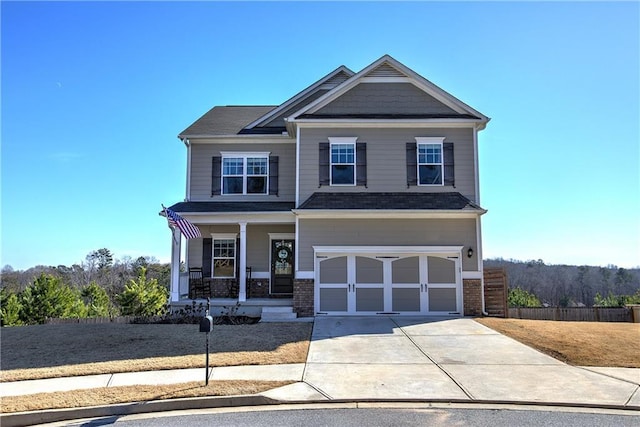 craftsman house with brick siding, covered porch, an attached garage, and concrete driveway