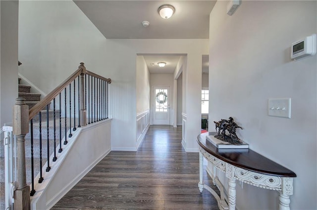 foyer entrance featuring stairs, baseboards, and dark wood-style flooring