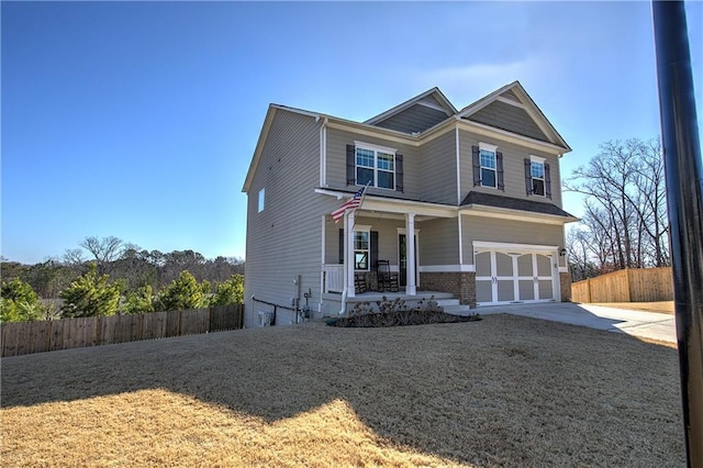 view of front of home with a porch, a garage, and a front yard