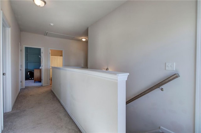 hall with an upstairs landing and light colored carpet