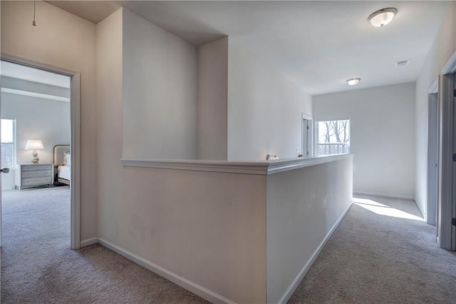 hallway with visible vents, baseboards, and carpet