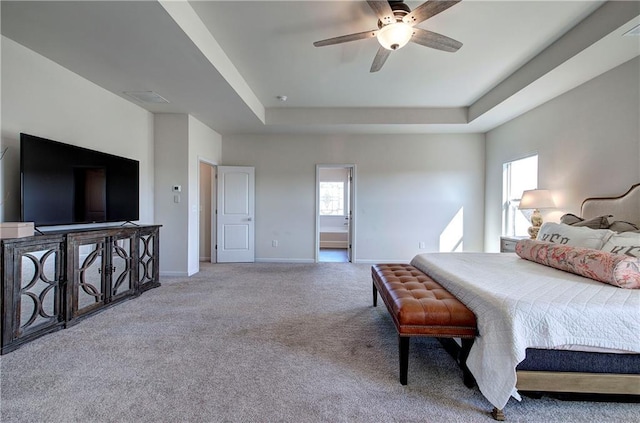 bedroom featuring ceiling fan, a raised ceiling, and light carpet