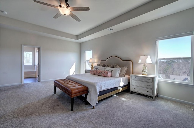 bedroom featuring a raised ceiling, visible vents, baseboards, and carpet floors