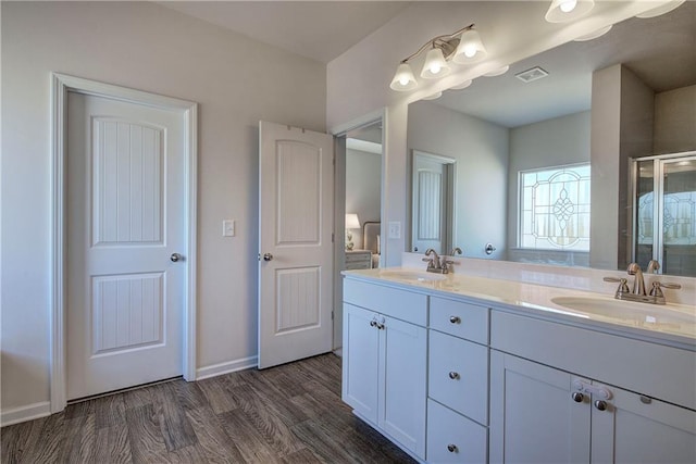 bathroom with wood-type flooring, vanity, and walk in shower