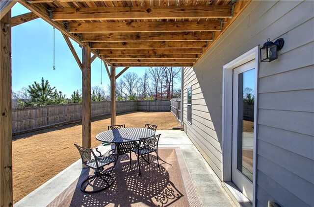 rear view of house with ceiling fan, a balcony, a patio, and a lawn