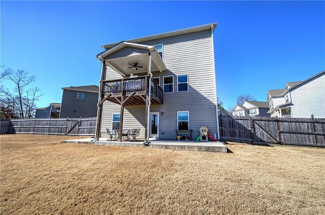 rear view of property featuring a patio, a balcony, ceiling fan, and a lawn