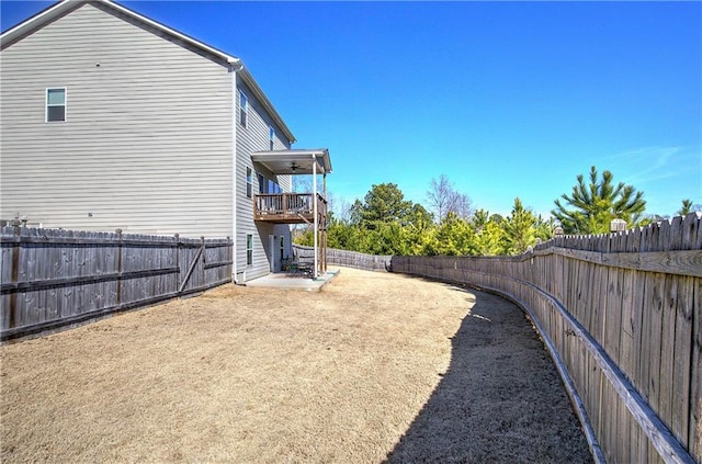 view of yard with a fenced backyard and ceiling fan