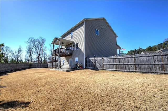 back of property featuring stairway, a lawn, a fenced backyard, and a ceiling fan