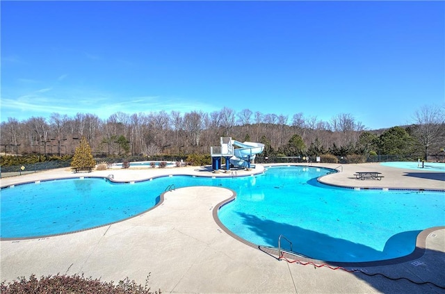 pool with a water slide and a patio