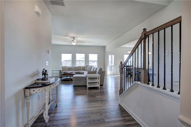 living room featuring dark wood-type flooring and ceiling fan