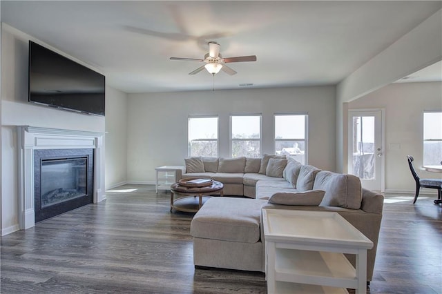 living area with a premium fireplace, plenty of natural light, and dark wood-style flooring