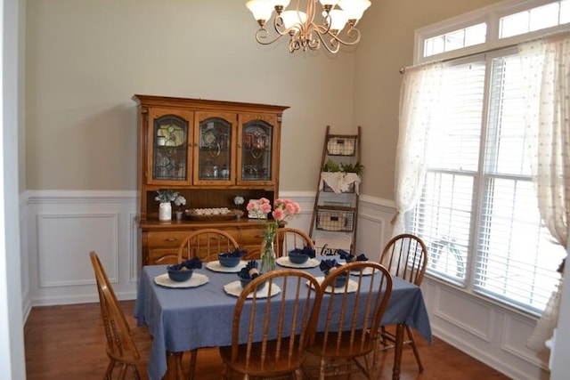 dining area featuring dark hardwood / wood-style flooring, a healthy amount of sunlight, and an inviting chandelier