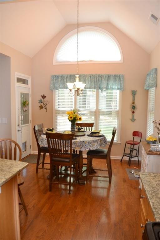 dining room with an inviting chandelier, hardwood / wood-style floors, and plenty of natural light