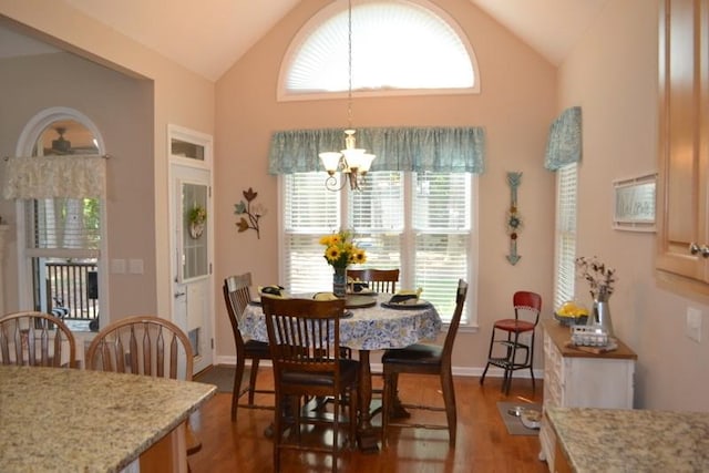 dining space featuring dark hardwood / wood-style flooring, vaulted ceiling, and a notable chandelier