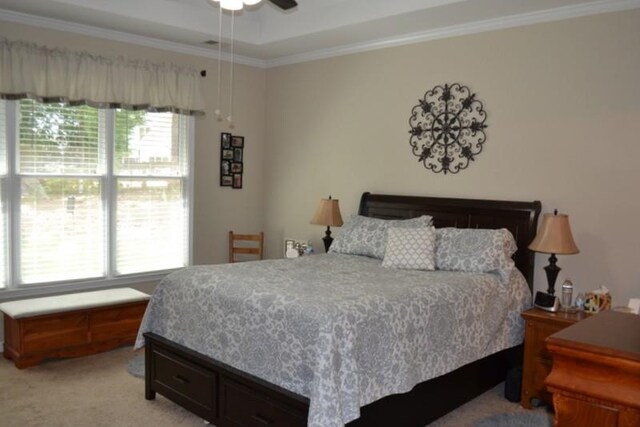 carpeted bedroom with ornamental molding and ceiling fan