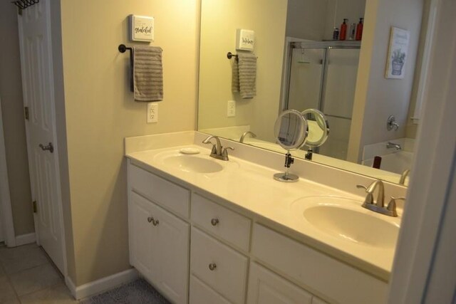 bathroom featuring vanity, a shower with door, and tile patterned floors