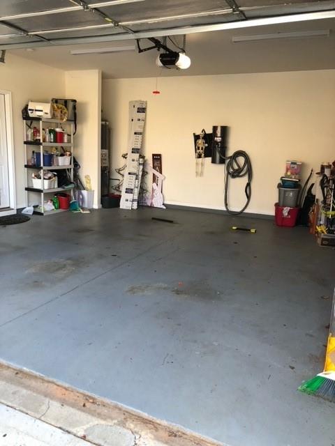 garage featuring a garage door opener and water heater