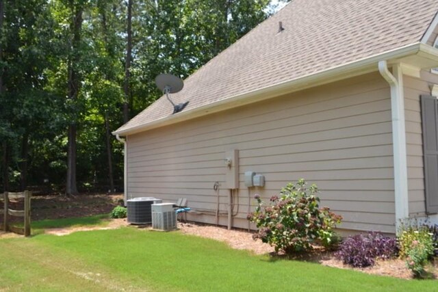 view of property exterior with a yard and central air condition unit