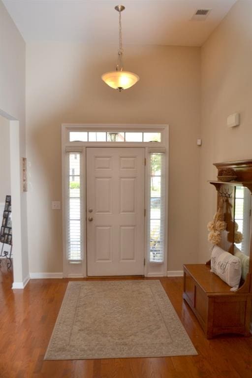 entryway featuring hardwood / wood-style flooring and a high ceiling