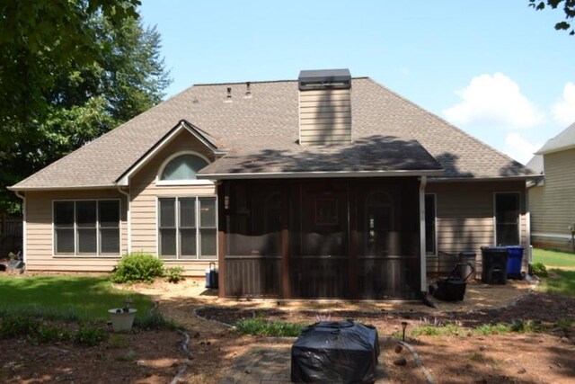 rear view of house featuring a sunroom