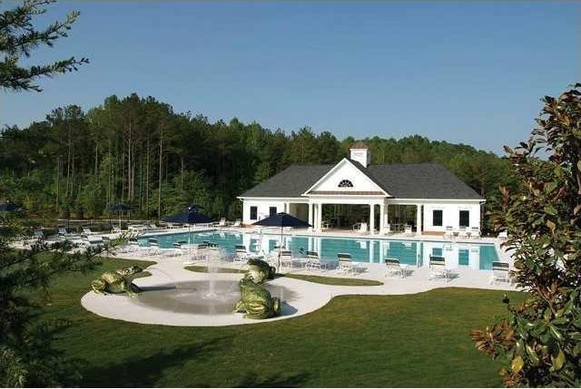 rear view of property with a community pool, a lawn, and a patio area