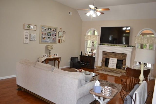 living room featuring vaulted ceiling, wood-type flooring, ceiling fan, and a fireplace