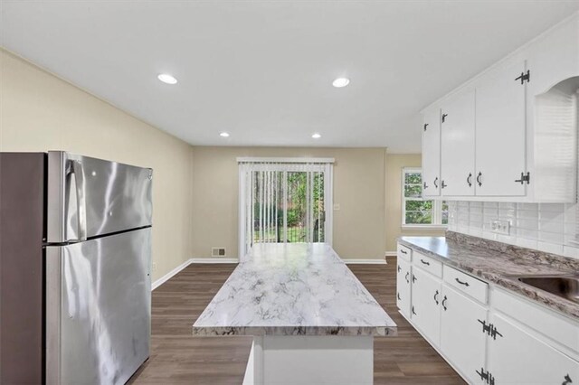 9258 Westview Dr SW, Covington, GA 30014 - kitchen with dark wood-style flooring, backsplash, a kitchen island, freestanding refrigerator, and white cabinets