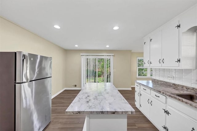 9258 Westview Dr SW, Covington, GA 30014 - kitchen with backsplash, a kitchen island, freestanding refrigerator, white cabinets, and dark wood-type flooring