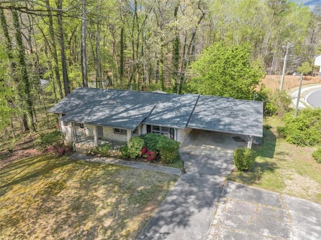 9258 Westview Dr SW, Covington, GA 30014 - exterior space with an attached carport, covered porch, concrete driveway, and a forest view