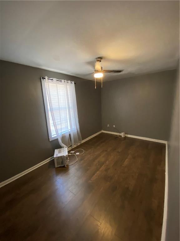 3734 Travis Blvd, Macon, GA 31206 - empty room with dark wood-style floors, baseboards, and ceiling fan