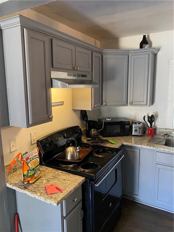 3734 Travis Blvd, Macon, GA 31206 - kitchen with black appliances, under cabinet range hood, gray cabinetry, and light stone countertops