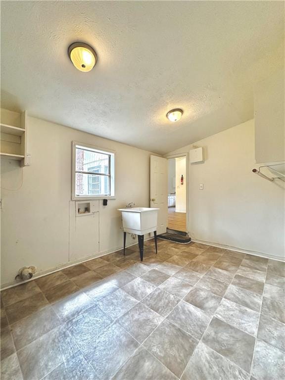 interior space featuring baseboards, a textured ceiling, washer hookup, and laundry area