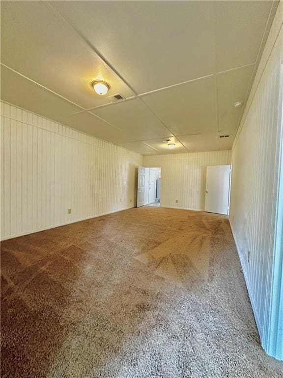 empty room with visible vents and carpet flooring