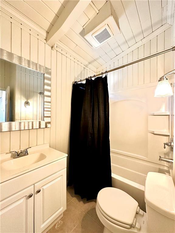 bathroom with tile patterned flooring, shower / bath combination with curtain, toilet, and vanity