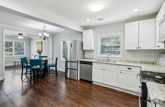 kitchen featuring dark wood finished floors, white cabinets, appliances with stainless steel finishes, pendant lighting, and a sink